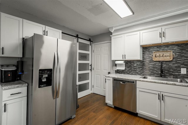 2003 Kysar Rd, Poplar Bluff, MO 63901 - kitchen with appliances with stainless steel finishes, decorative backsplash, white cabinetry, dark wood-type flooring, and a sink