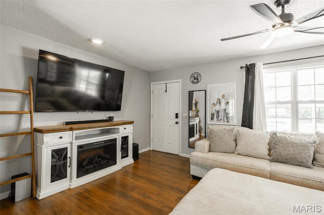 2003 Kysar Rd, Poplar Bluff, MO 63901 - living area featuring ceiling fan, dark wood-type flooring, a fireplace, a textured ceiling, and baseboards