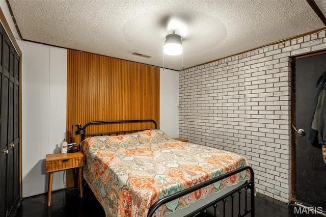 2003 Kysar Rd, Poplar Bluff, MO 63901 - bedroom featuring brick wall, a closet, a textured ceiling, and a ceiling fan
