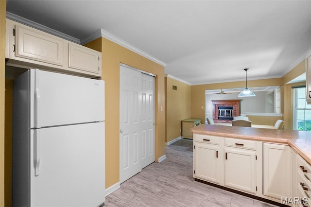 1439 Briarcreek Dr, Saint Louis, MO 63122 - kitchen with freestanding refrigerator, a brick fireplace, crown molding, pendant lighting, and light countertops