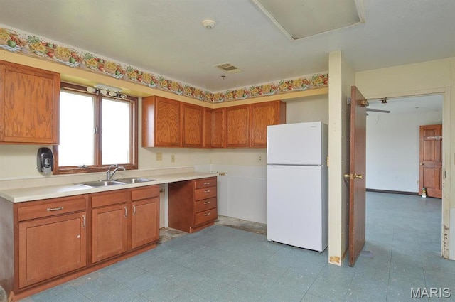 620 N Main St, Hoyleton, IL 62803 - kitchen featuring freestanding refrigerator, a sink, brown cabinetry, and light countertops
