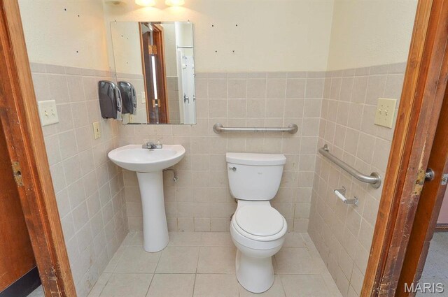 620 N Main St, Hoyleton, IL 62803 - half bathroom featuring tile walls, toilet, a sink, a wainscoted wall, and tile patterned floors