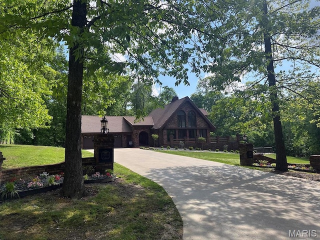 15012 Bay Hills Dr, Dexter, MO 63841 - tudor house with concrete driveway, a front lawn, and a garage