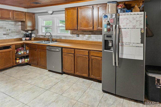 519 N Maple St, Duquoin, IL 62832 - kitchen featuring appliances with stainless steel finishes, a sink, brown cabinetry, and decorative backsplash