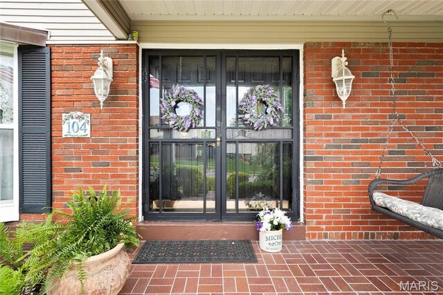 doorway to property featuring brick siding and french doors