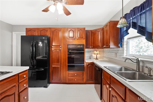 kitchen featuring black appliances, a warming drawer, a sink, light countertops, and a ceiling fan