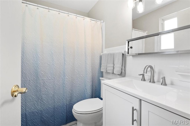 full bathroom with toilet, vanity, wainscoting, tile walls, and a shower with shower curtain