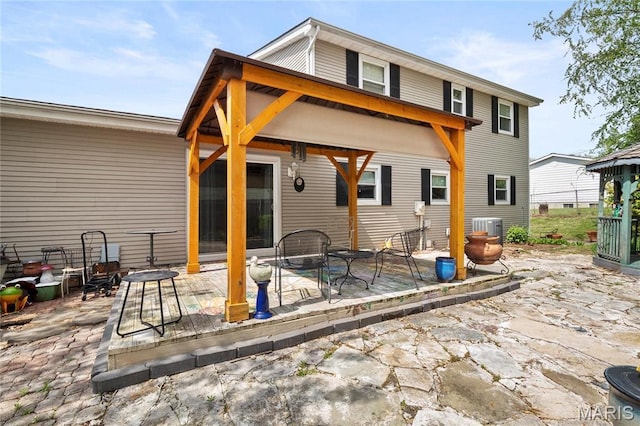 rear view of property featuring a patio and cooling unit