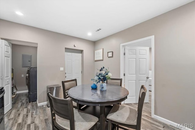 1428 Mallinckrodt, Saint Louis, MO 63107 - dining room featuring light wood finished floors, washer / dryer, electric panel, baseboards, and recessed lighting