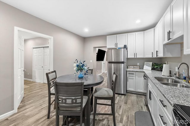 1428 Mallinckrodt, Saint Louis, MO 63107 - kitchen featuring stainless steel appliances, a sink, light wood-type flooring, baseboards, and recessed lighting