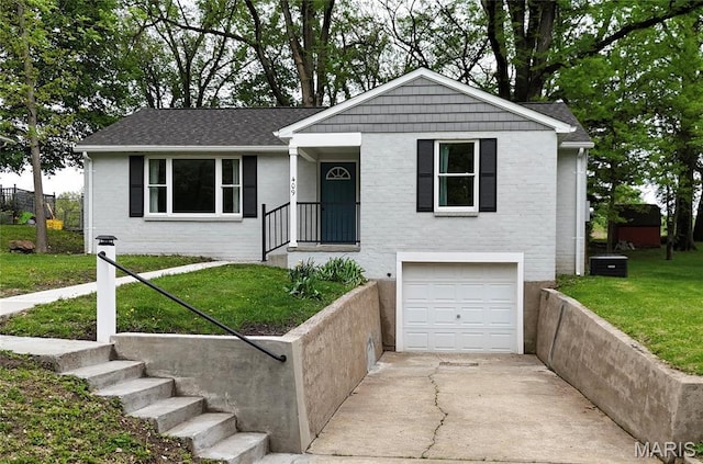 409 Oak St, East Alton, IL 62024 - single story home featuring a garage, a front lawn, driveway, and central air condition unit