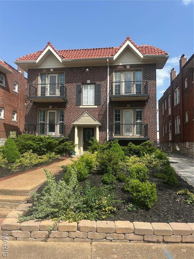 916 Eastgate Ave, Saint Louis, MO 63130 - view of front of home with a tile roof, a balcony, and brick siding