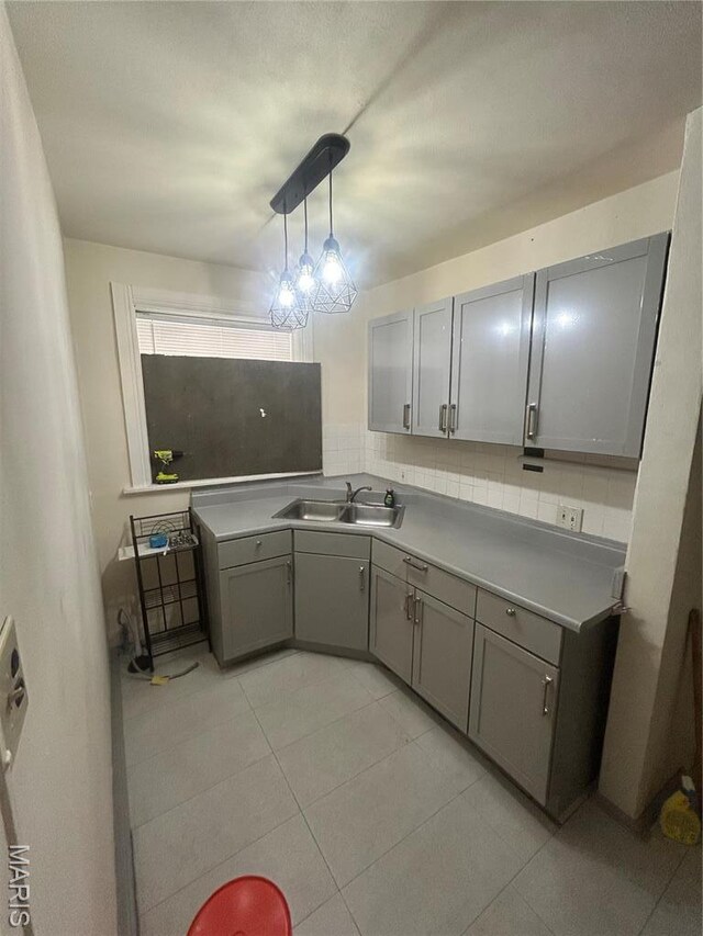 916 Eastgate Ave, Saint Louis, MO 63130 - kitchen with a sink, gray cabinets, light tile patterned flooring, light countertops, and tasteful backsplash