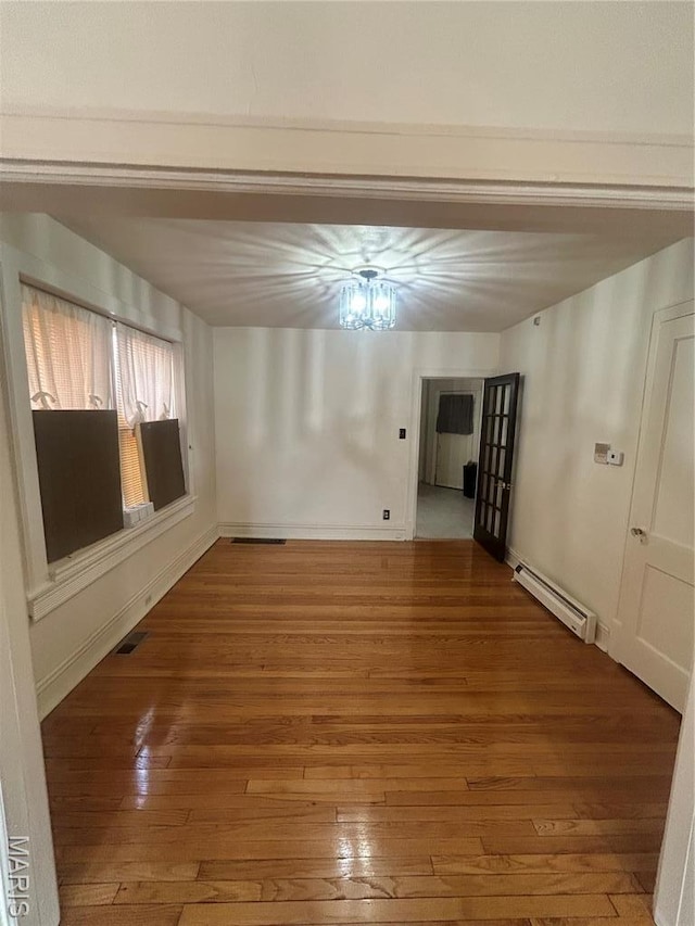 916 Eastgate Ave, Saint Louis, MO 63130 - spare room featuring a baseboard heating unit, hardwood / wood-style floors, and baseboards