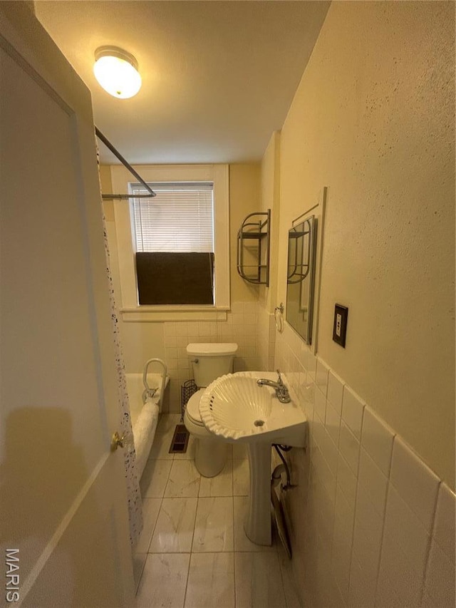916 Eastgate Ave, Saint Louis, MO 63130 - full bathroom with tile walls, marble finish flooring, toilet, a wainscoted wall, and a sink