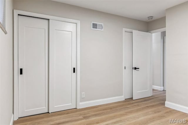 1548 Park Dr Way, Saint Louis, MO 63130 - unfurnished bedroom featuring light wood-style floors, baseboards, and two closets