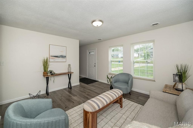 1331 Belrue Ave, Saint Louis, MO 63133 - living area featuring wood finished floors, a textured ceiling, and baseboards