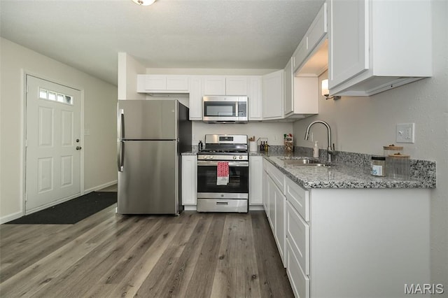 1331 Belrue Ave, Saint Louis, MO 63133 - kitchen featuring stainless steel appliances, a sink, wood finished floors, and white cabinetry