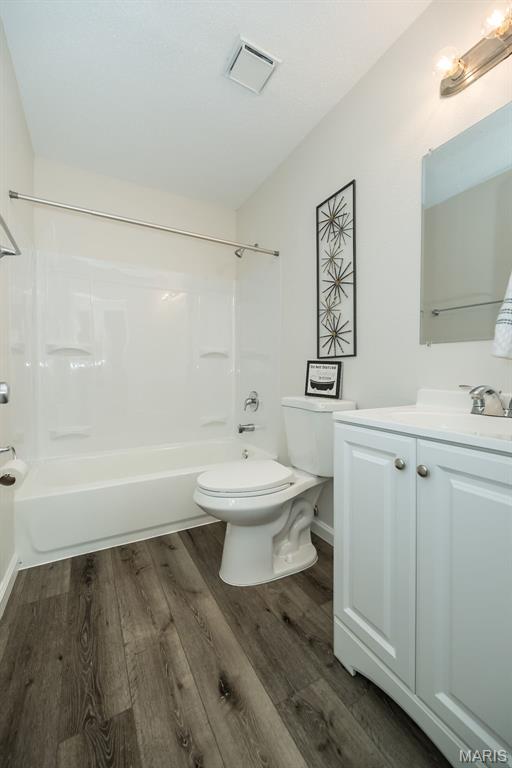 1331 Belrue Ave, Saint Louis, MO 63133 - bathroom with toilet, wood finished floors, shower / washtub combination, and vanity