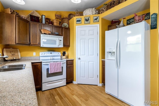 8007 Engleford Rd, Dittmer, MO 63023 - kitchen featuring white appliances, a sink, and light wood-style floors