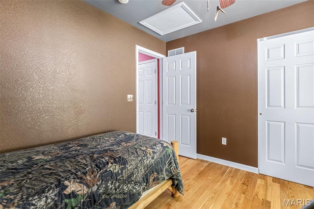 8007 Engleford Rd, Dittmer, MO 63023 - bedroom with light wood-style flooring, baseboards, attic access, a ceiling fan, and a textured wall