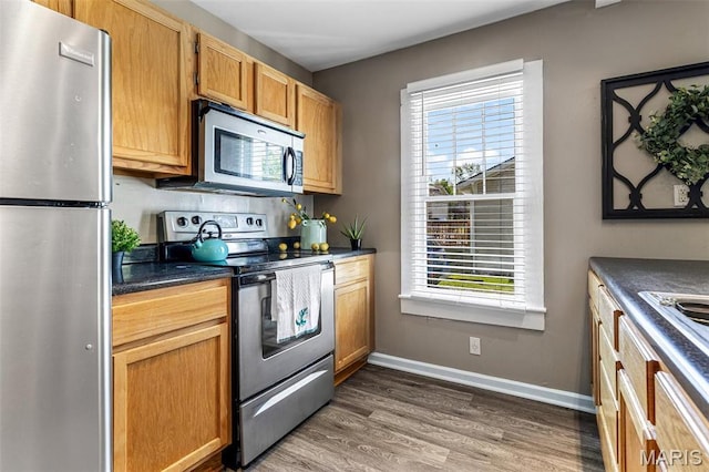 314 S Carleton St, Farmington, MO 63640 - kitchen featuring appliances with stainless steel finishes, dark countertops, wood finished floors, and baseboards