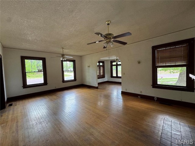 813 Main St, Poplar Bluff, MO 63901 - spare room featuring a textured ceiling, hardwood / wood-style floors, ceiling fan, arched walkways, and baseboards
