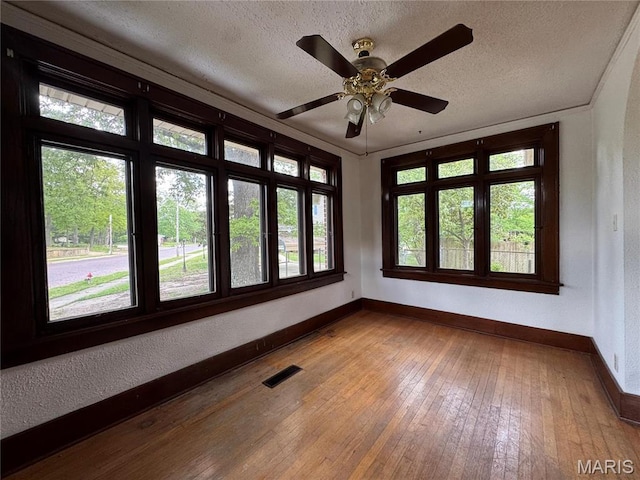 813 Main St, Poplar Bluff, MO 63901 - spare room featuring baseboards, a textured ceiling, healthy amount of natural light, wood-type flooring, and a ceiling fan