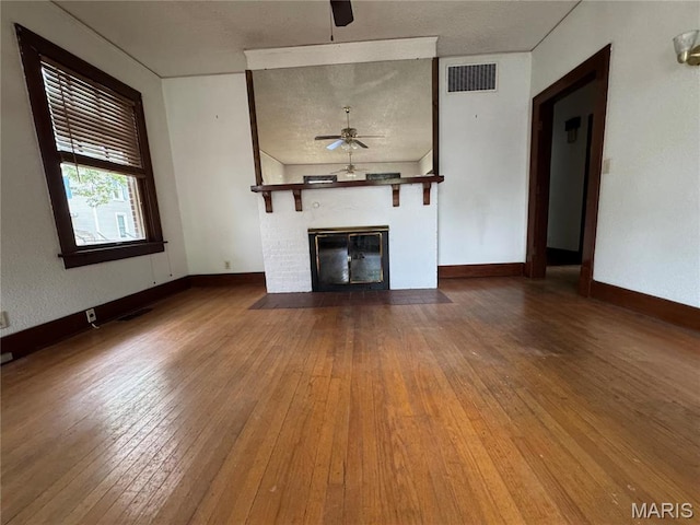 813 Main St, Poplar Bluff, MO 63901 - unfurnished living room featuring ceiling fan, a fireplace with flush hearth, hardwood / wood-style flooring, and baseboards