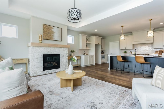 837 Bushwood Way, Ofallon, IL 62269 - living room featuring recessed lighting, dark wood-style floors, a raised ceiling, and a stone fireplace