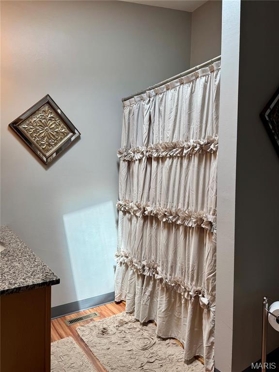 1725 Spruce Hill Dr, Belleville, IL 62221 - full bath featuring wood finished floors, vanity, and a shower with shower curtain