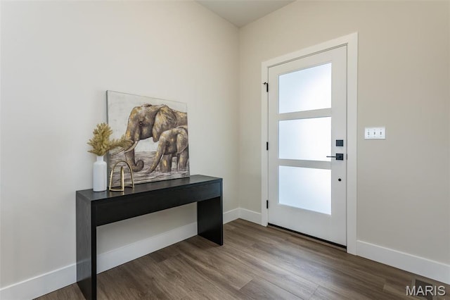 doorway with dark wood-style floors and baseboards