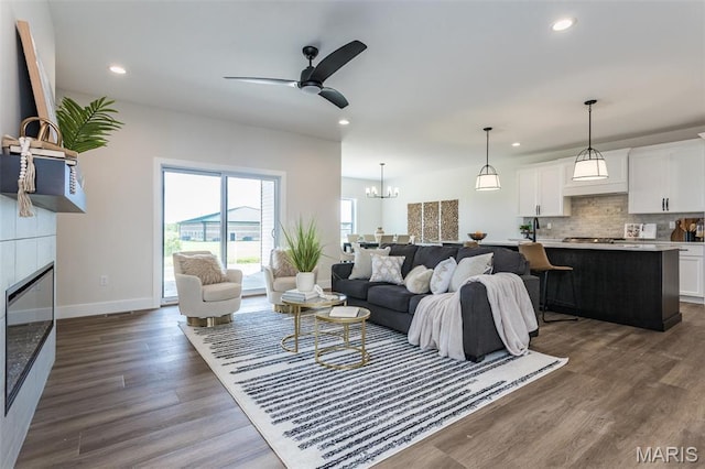 living area featuring recessed lighting, a ceiling fan, a tile fireplace, dark wood-style flooring, and baseboards