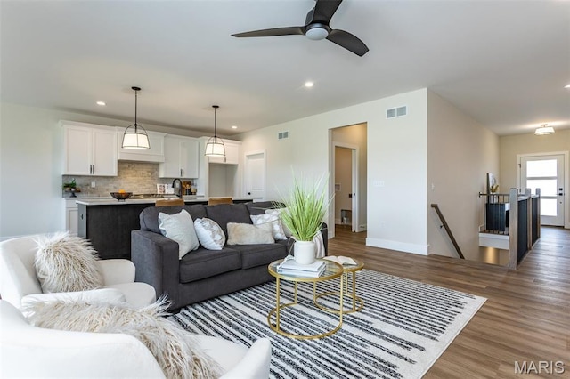 living area with wood finished floors, recessed lighting, baseboards, and ceiling fan