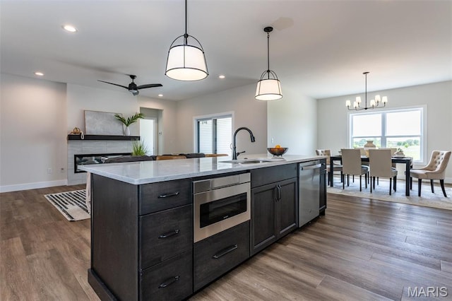 kitchen featuring a sink, dishwasher, plenty of natural light, dark wood finished floors, and recessed lighting
