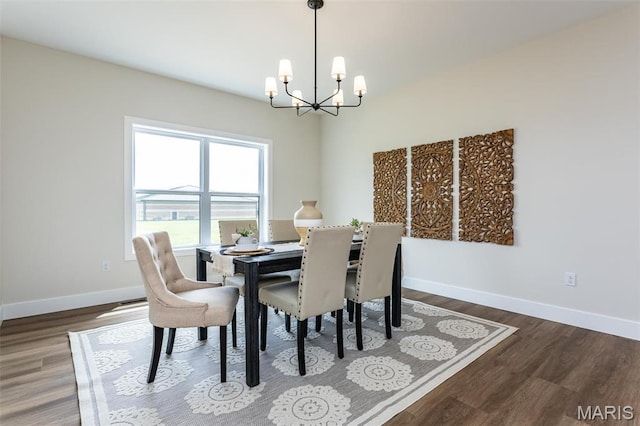 dining room with a chandelier, baseboards, and wood finished floors