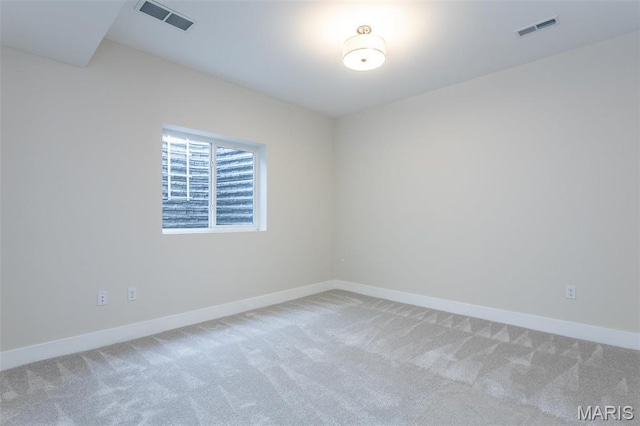 unfurnished room featuring light colored carpet and baseboards