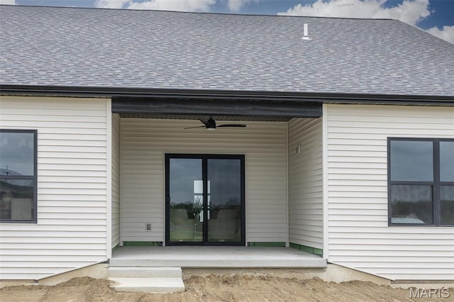 back of house featuring ceiling fan and a shingled roof