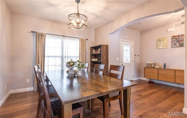 1347 Thomas Dr, Rolla, MO 65401 - dining space with dark wood-type flooring, arched walkways, baseboards, a chandelier, and plenty of natural light