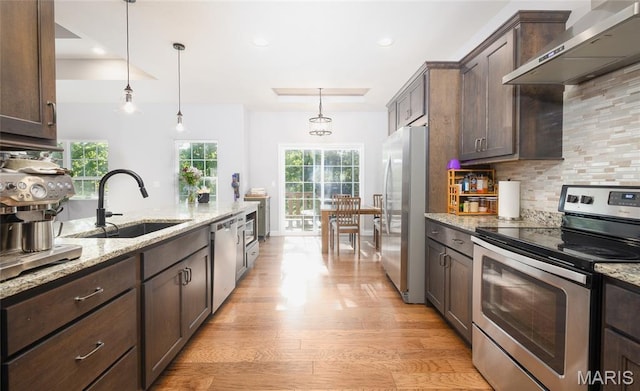 1347 Thomas Dr, Rolla, MO 65401 - kitchen with stainless steel appliances, wall chimney range hood, a sink, dark brown cabinetry, and recessed lighting