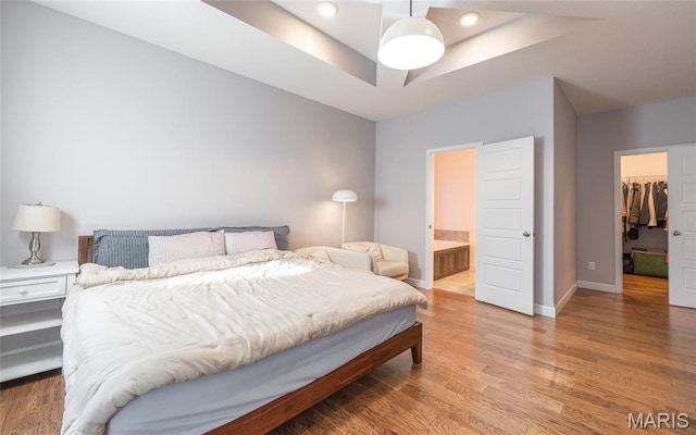 1347 Thomas Dr, Rolla, MO 65401 - bedroom featuring a raised ceiling, a walk in closet, light wood-style floors, baseboards, and a closet