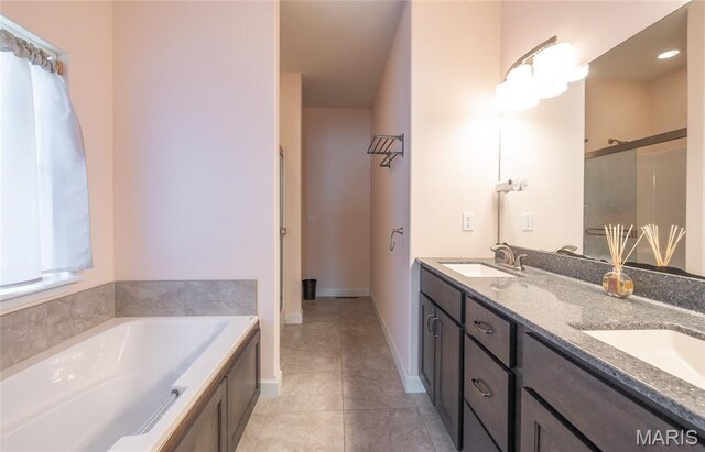 1347 Thomas Dr, Rolla, MO 65401 - full bathroom featuring double vanity, a garden tub, tile patterned flooring, and baseboards
