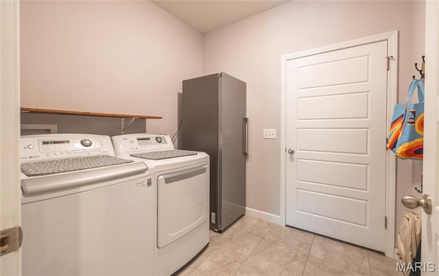 1347 Thomas Dr, Rolla, MO 65401 - laundry room featuring washing machine and dryer, light tile patterned floors, and baseboards