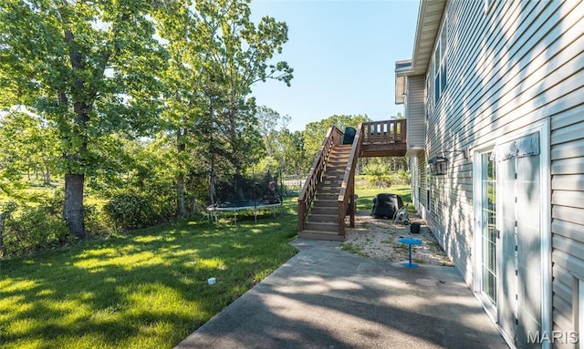 1347 Thomas Dr, Rolla, MO 65401 - view of green lawn featuring a trampoline, stairway, and a patio area