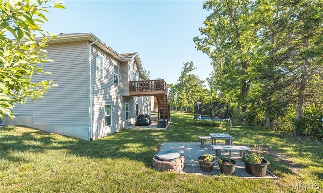 1347 Thomas Dr, Rolla, MO 65401 - view of grassy yard with a trampoline, stairs, a patio, and a wooden deck