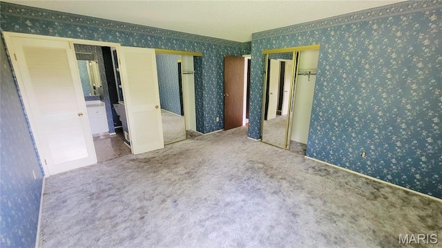 5489 Limerick Dr, Saint Louis, MO 63128 - unfurnished bedroom featuring wallpapered walls, multiple closets, and carpet