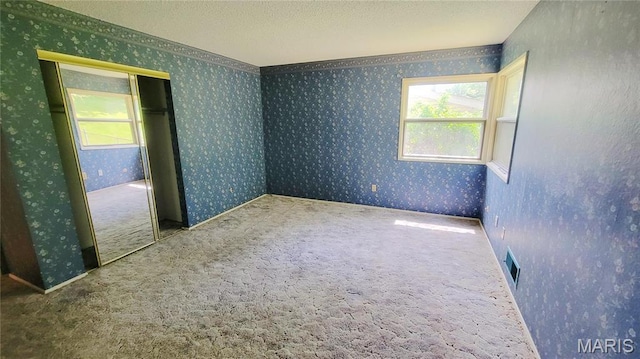 5489 Limerick Dr, Saint Louis, MO 63128 - empty room featuring healthy amount of natural light, wallpapered walls, and carpet floors