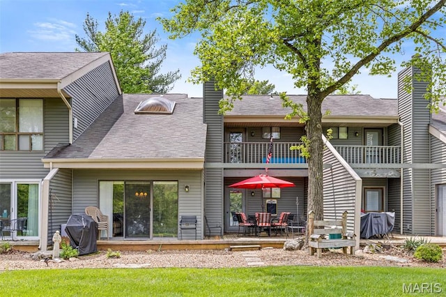 45 S Lionshead Dr, Innsbrook, MO 63390 - back of house featuring a balcony, a chimney, a shingled roof, and a lawn