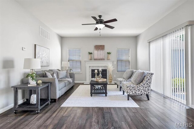 153 Stella Cherry Way, Wildwood, MO 63040 - living area featuring dark wood-style flooring, a ceiling fan, a fireplace, and baseboards