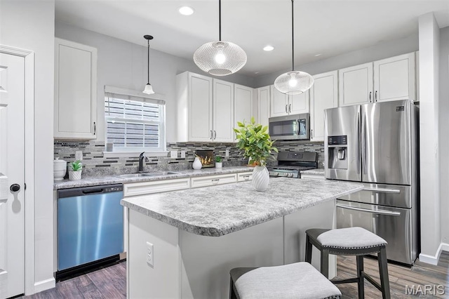 153 Stella Cherry Way, Wildwood, MO 63040 - kitchen featuring stainless steel appliances, a sink, a breakfast bar area, wood finished floors, and decorative backsplash